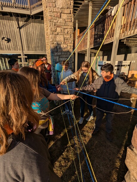 Pathfinders work together untangling ropes.