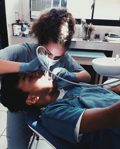 Student missionary hygienist cleans a patient's teeth
